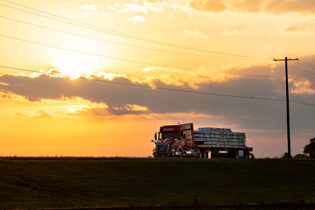 A line of trucks parked side-by-side on a lot.